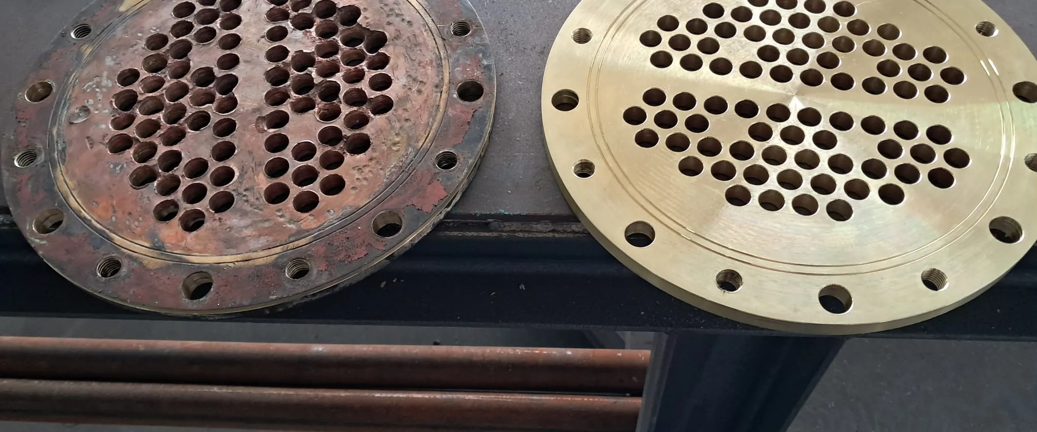 The removed tube sheet beside the newly fabricated one